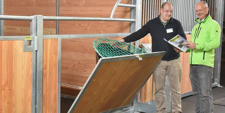 Zwei Männer vor einer Box für Pferde