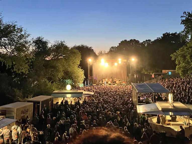 Music stage at the Fährmannsfest, numerous people in front of it.