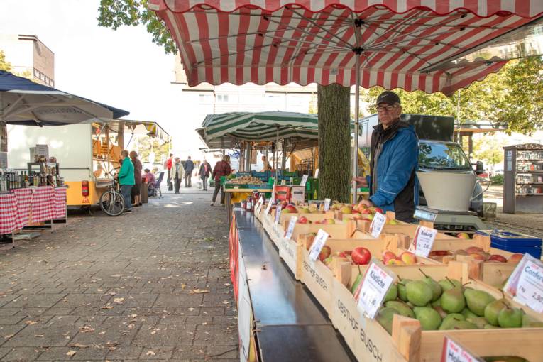 Ein Verkäufer an einem Obststand auf dem Wochenmarkt.