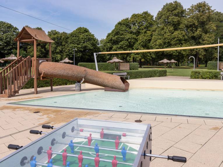 Kicker und Rutsche in Form eines Baumstammes im Aussenbereich des Hallenfreibades Burgdorf