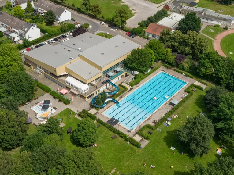 Luftbild von Schwimmhalle, Aussenbecken und Freigelände