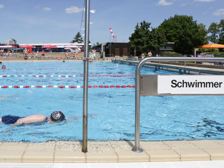 Schwimmerin mit Badekappe im Freibad