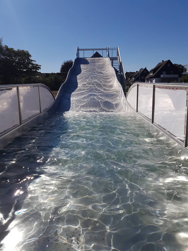 Sehr breite Metallrutsche auf der Wasser ist