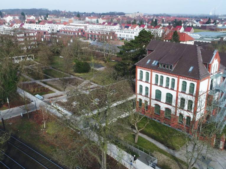 Ein Gebäude und das dazugehörige Gelände (inklusive Garten) von oben fotografiert.