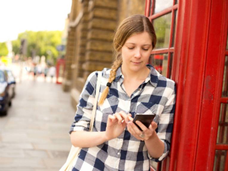 Frau vor Telefonzelle