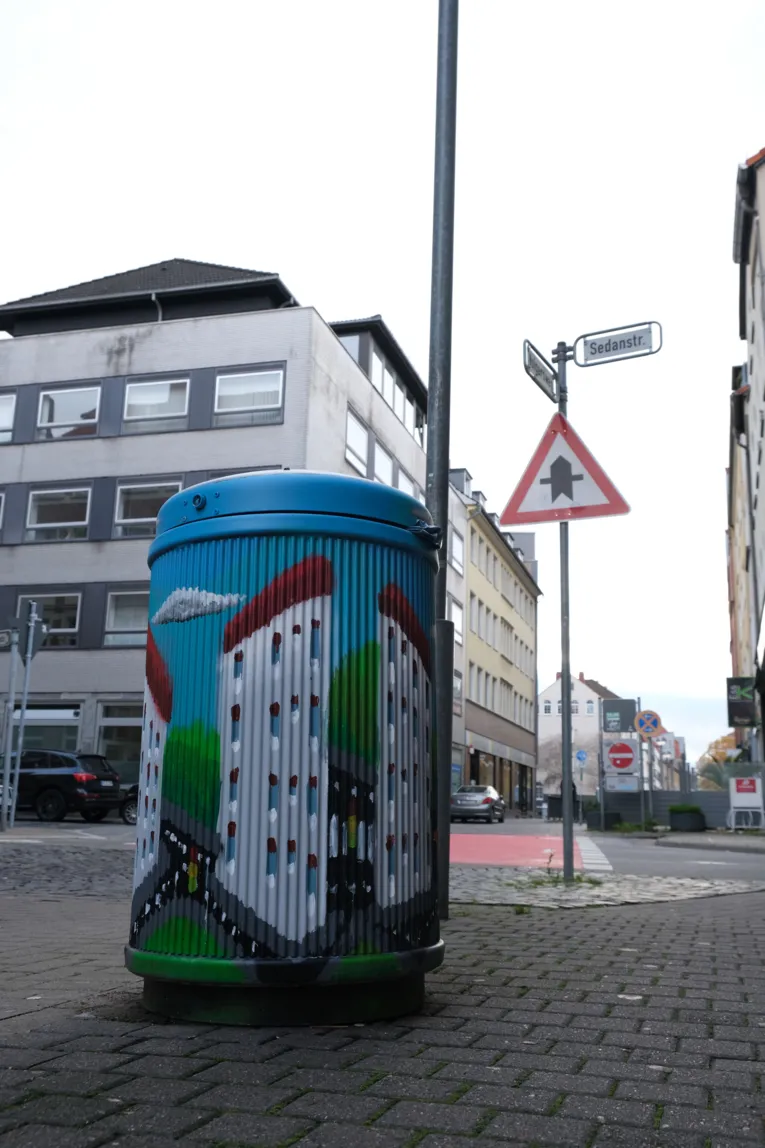 Taiteellinen roskakori Volgerswegin ja Sedanstraßen risteyksessä