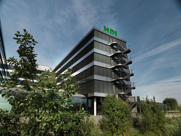 Auf einem modernen Bürogebäude sind die Buchstaben HDI zu sehen.