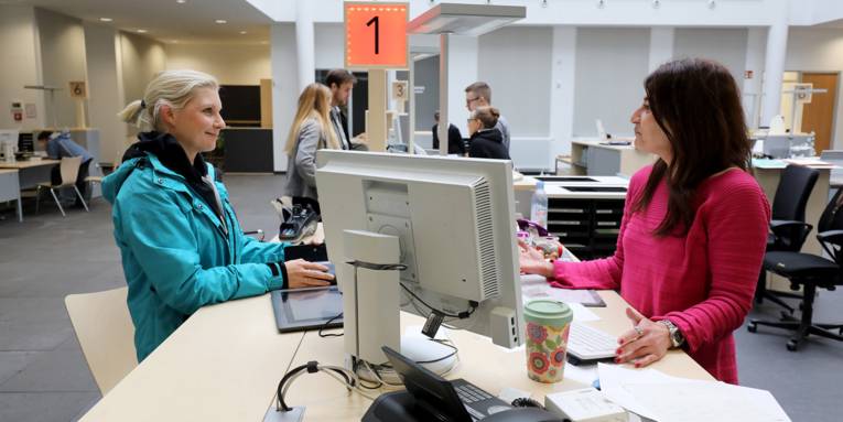 A citizen in conversation with a clerk at the Aegi Citizens' Office