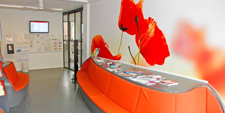 Un grand canapé incurvé et un immense tableau représentant des tulipes dominent la salle d'attente du centre administratif de Linden