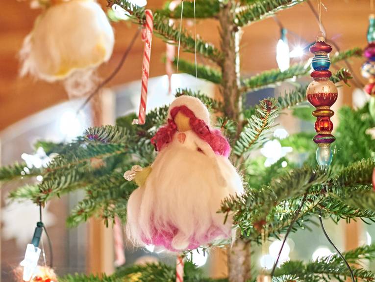 Close-up of a small handmade doll hanging from a Christmas tree as a decoration