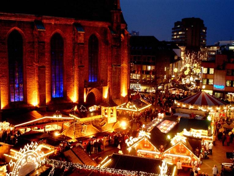 View from above of the illuminated nave of the Marktkirche and the Christmas market stalls set up