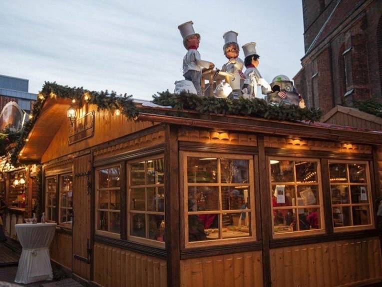 Three figures on a wooden roof point the way to the Christmas bakery