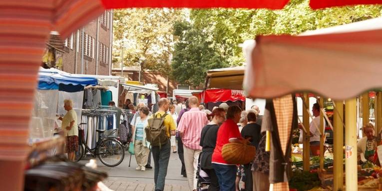 Zwischen den Marktständen flanieren die Kundinnen und Kunden