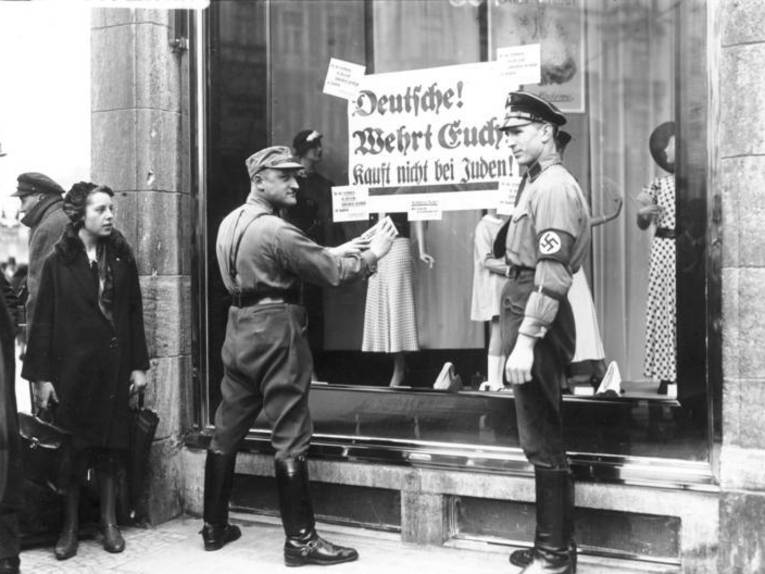 SA - Mitglieder kleben an das Schaufenster eines Berliner jüdischen Geschäfts ein Schilder mit der Aufschrift "Deutsche, wehrt euch, kauft nicht bei Juden"