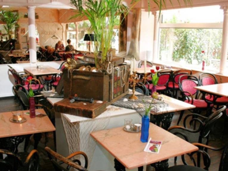 Ein Restaurant. In der Mitte steht eine Schatztruhe auf dem Tisch.