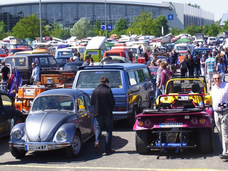 Viele Fahrzeuge auf einem Parkplatz, den Autokennzeichen nach aus vielen verschiedenen Städten.