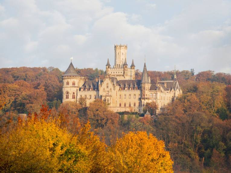 Schloss in einer Herbstlandschaft.
