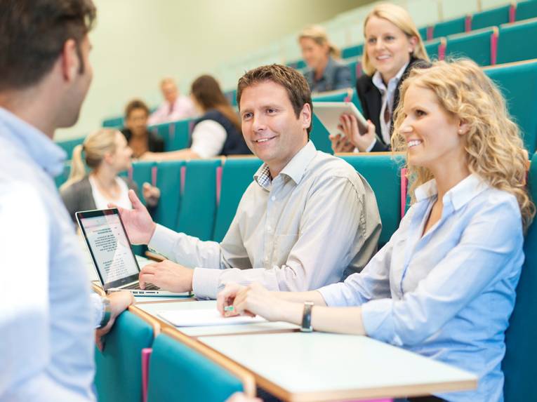 Eine Frau und ein Mann im Gespräch mit einem weiteren Mann.