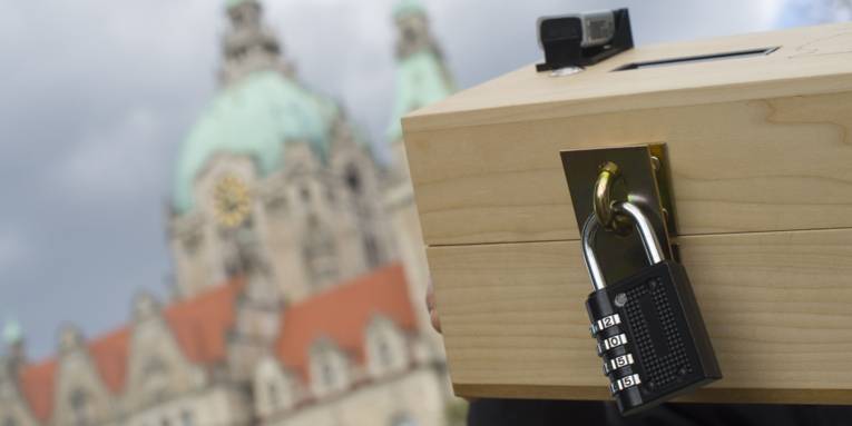 Holzbox mit Zahlenschloss und kleinen elektronischem Gerät