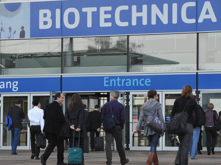 Menschen vor dem Eingang zu einer Messehalle mit dem Schriftzug Biotechnica.