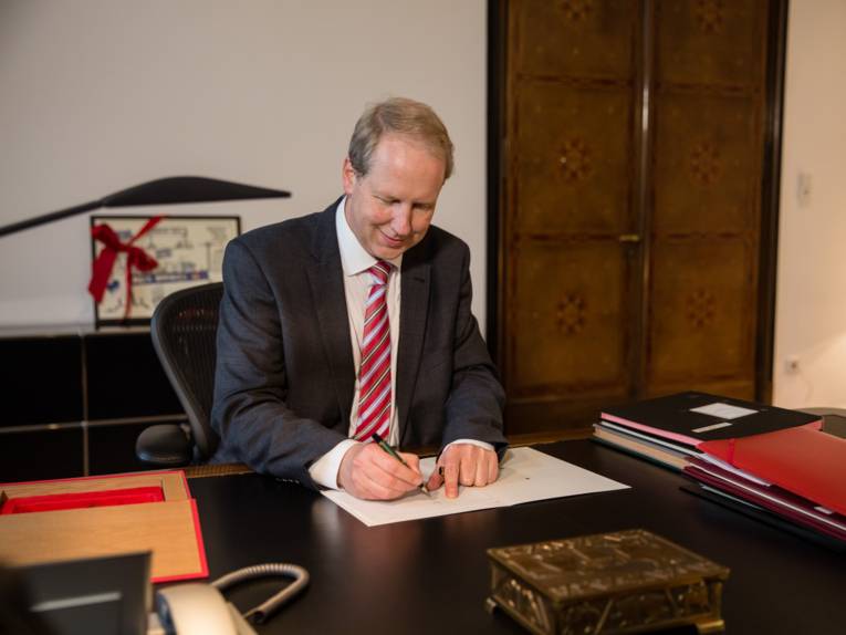 Stefan Schostok unterschreibt ein Dokument an seinem Schreibtisch