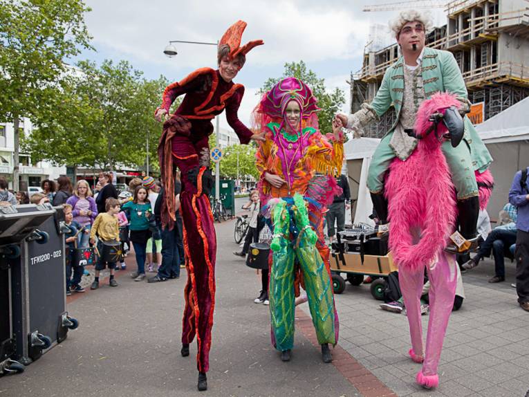 Drei exotisch anmutende, fantasievoll gekleidete und übergroße Figuren in Hannovers Innenstadt