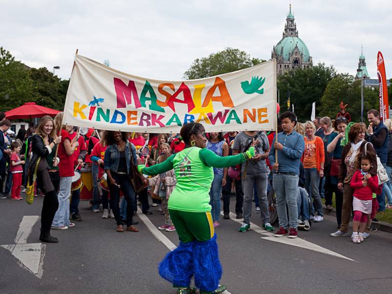 Eine Tänzerin tanzt vor der Masala Kinderkarawane auf der Straße