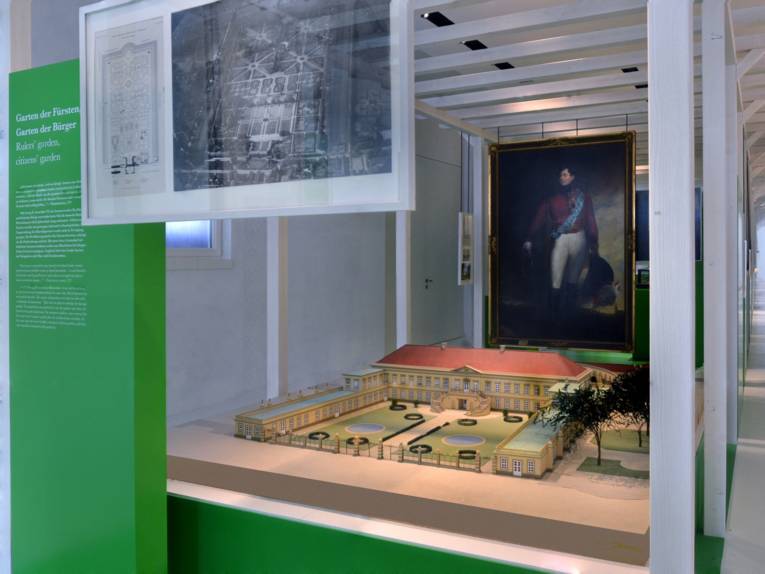 Blick in den Gartenflügel des Museums Schloss Herrenhausen, im Zentrum des Bildes ein Modell des Schlosses aus früheren Zeiten, im Hintergrund hängt ein großformatiges Gemälde