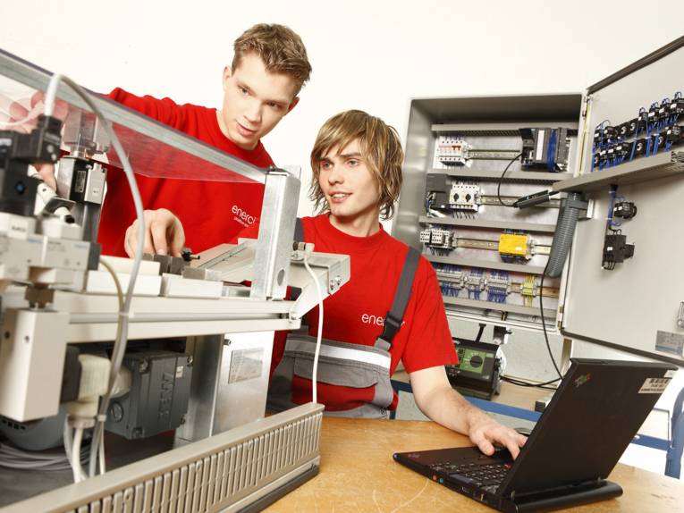 Zwei junge Männer mit Laptop und technischen Geräten