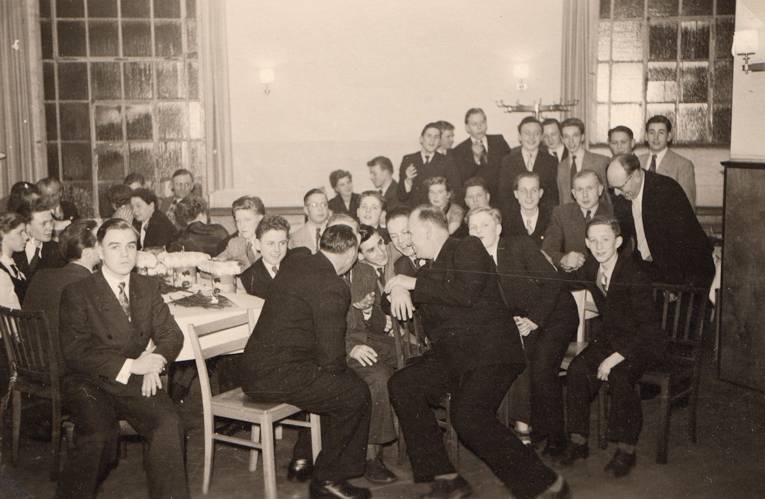 Männer und Frauen an Tischen sitzend (Schwarz-Weiß-Fotografie)