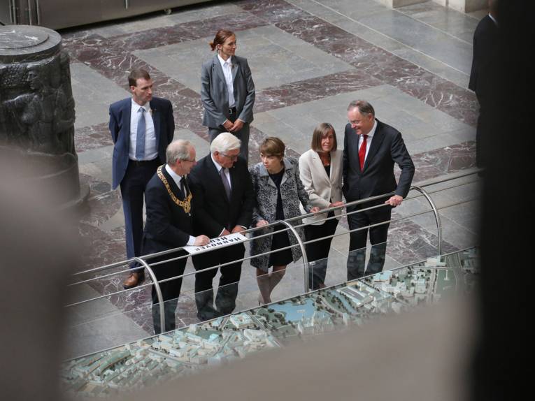 Stefan Schostok, Frank-Walter Steinmeier, Elke Büdenbender, Stephan Weil und Rosemarie Kerkow-Weil betrachten eines der Stadtmodelle in der Kuppelhalle des Rathauses
