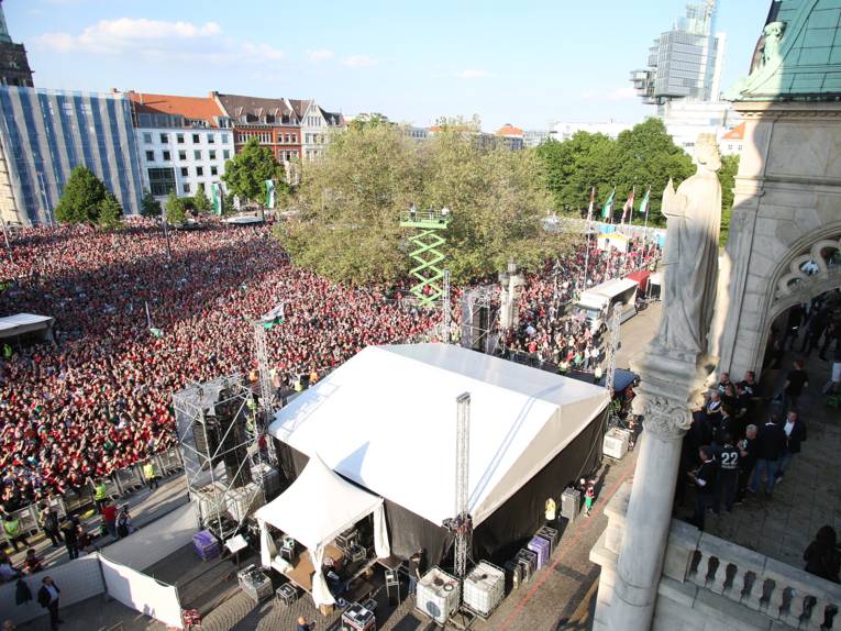 Menschen vor und in einem Rathaus. 
