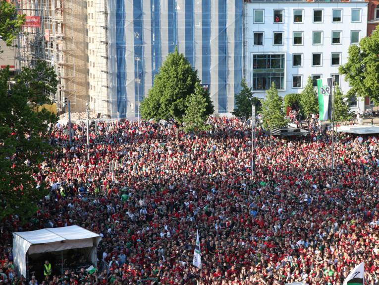 Menschen vor und in einem Rathaus. 