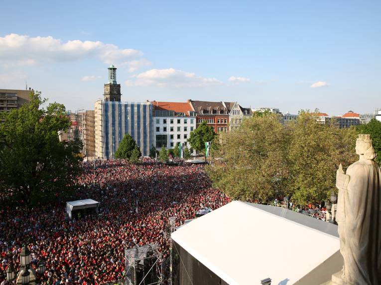 Menschen vor und in einem Rathaus. 