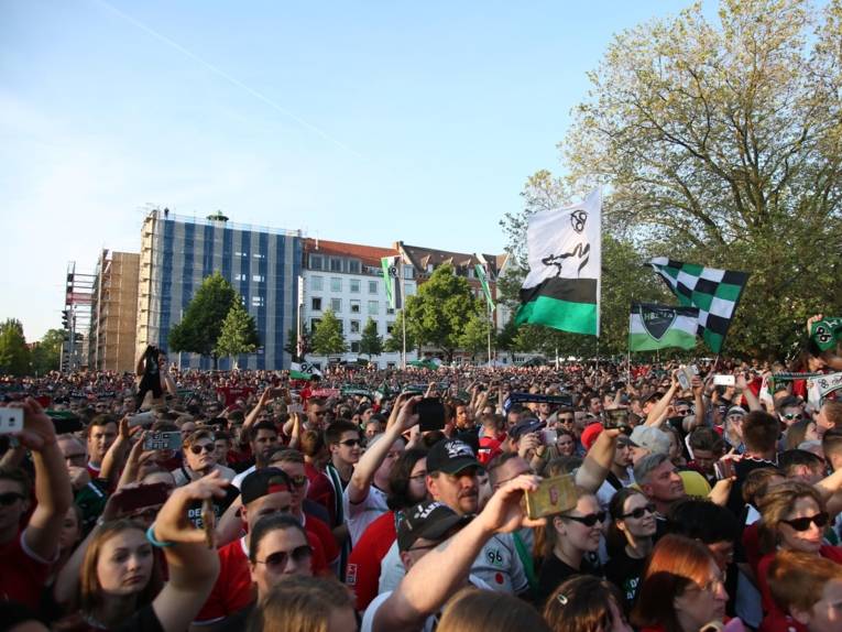 Menschen vor und in einem Rathaus. 