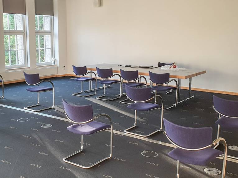 Ein Raum, in dem ein Tisch und mehrere Stühle stehen