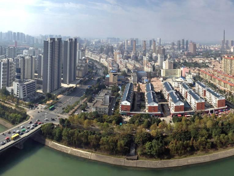 Blick aus der Vogelperspektive auf eine Stadt mit Wolkenkratzern und einem Fluss.