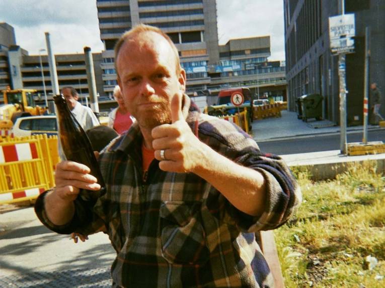 Fotografie, die einen Mann mit einer Bierflasche zeigt. 