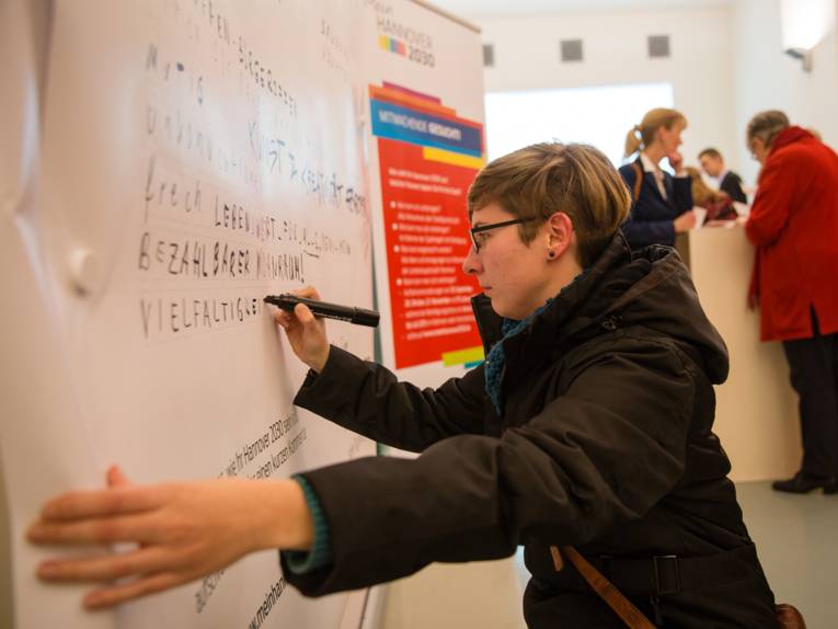 Eine Frau schreibt Wünsche für "Mein Hannover 2030" auf