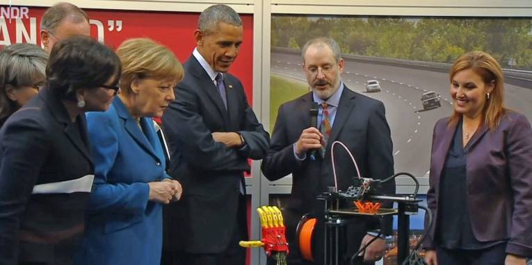 Mann zeigt anderen Menschen ein technisches Gerät.