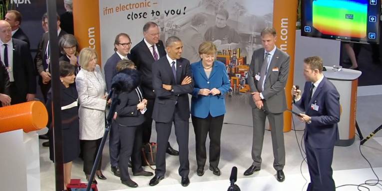 Männer und Frauen an einem Messestand