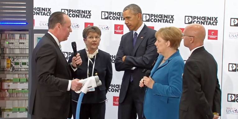 Mann zeigt anderen Leuten einen großen Elektrostecker