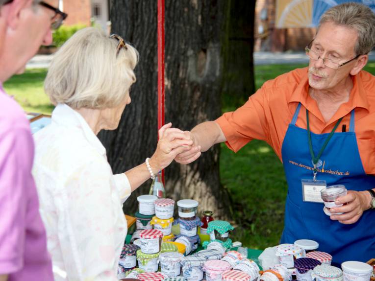 Ein Mann verkauft einer Frau Marmelade.