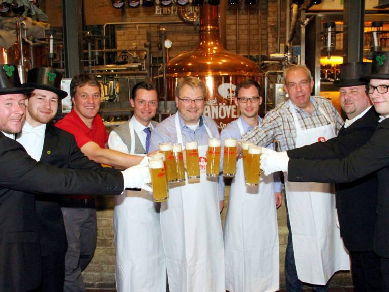 Neun Männer mit Bierkrügen. 